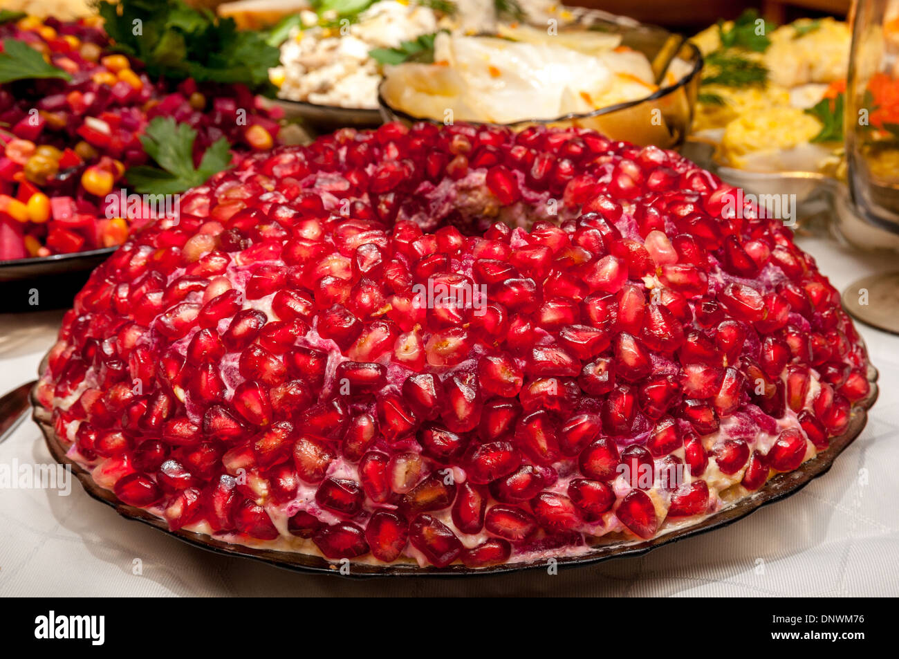 Piastra con insalata di bracciale granato sui vari alimenti sul retro background Foto Stock