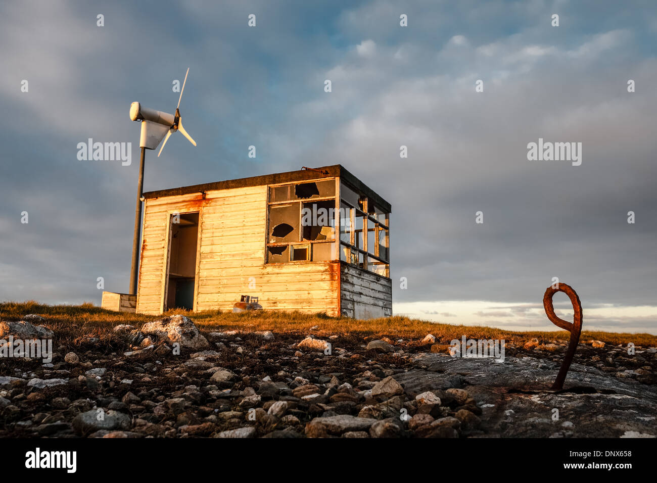 Guardia costiera vecchia capanna di vedetta e la turbina eolica sulla Out Skerries in Shetland Foto Stock