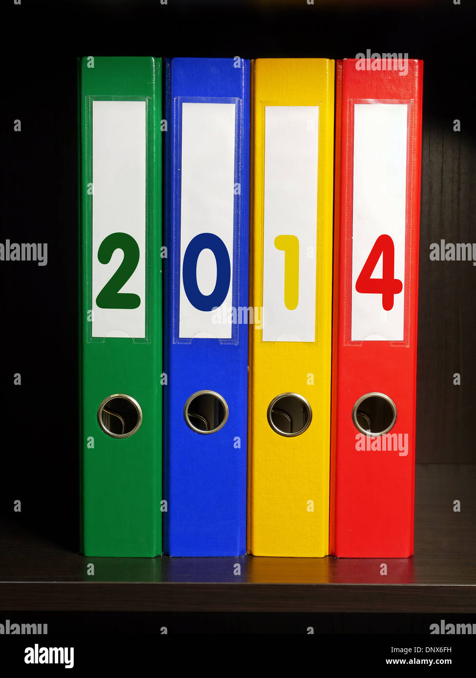 Quattro leganti di colore con il nuovo anno 2014 cifre poste su scaffale Foto Stock