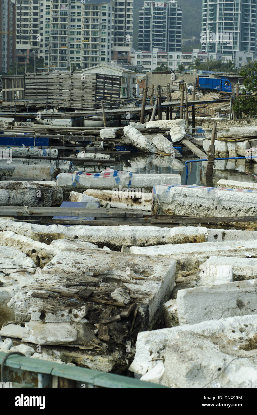 I pescatori e i lavoratori scaricano il legno tra mattoni di plastica e di styrofoam rotti e scartati, scatole e pile di imballaggio in un porto dove i pescherecci scaricano le loro catture. L'inquinamento è così esteso che alcune navi sono bloccate, incapaci di muoversi. Le aziende di pesca cinesi fanno inoltre ampio uso di scatole di polistirolo, dispositivi di galleggiamento e imballaggi che provocano danni ambientali e inquinano il mare e gli oceani, in quanto si rompe su e giù il nickel maltempo o a causa di uno smaltimento disattento. © Olli Geibel Foto Stock