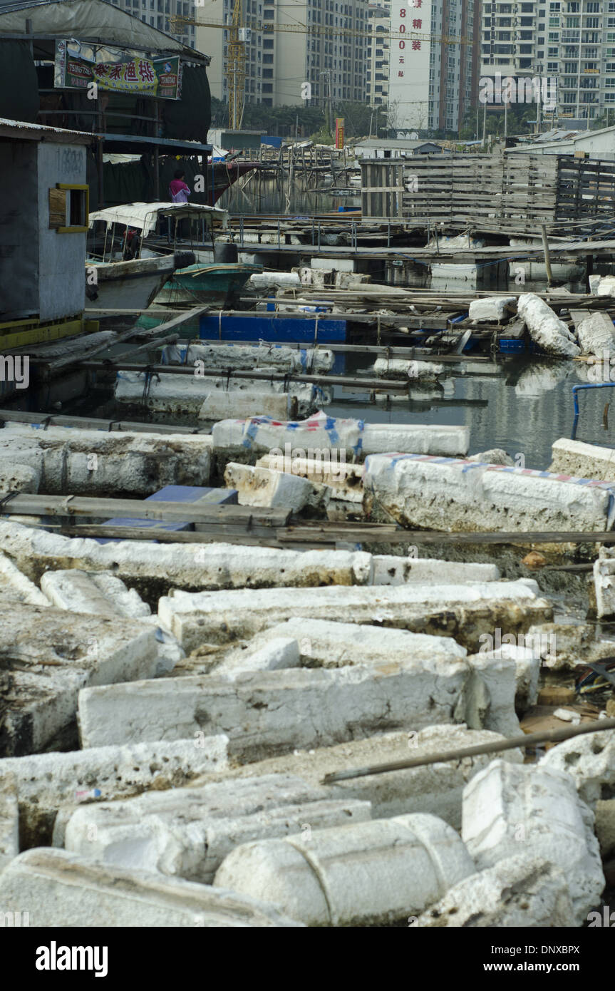 I pescatori e i lavoratori scaricano il legno tra mattoni di plastica e di styrofoam rotti e scartati, scatole e pile di imballaggio in un porto dove i pescherecci scaricano le loro catture. L'inquinamento è così esteso che alcune navi sono bloccate, incapaci di muoversi. Le aziende di pesca cinesi fanno inoltre ampio uso di scatole di polistirolo, dispositivi di galleggiamento e imballaggi che provocano danni ambientali e inquinano il mare e gli oceani, in quanto si rompe su e giù il nickel maltempo o a causa di uno smaltimento disattento. © Olli Geibel Foto Stock