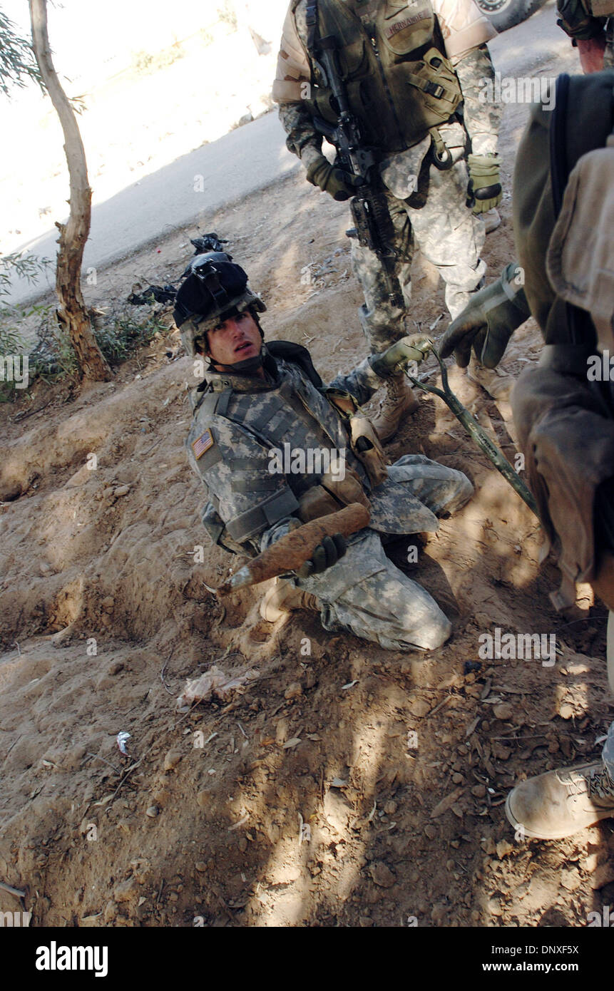 Dic 10, 2005; Bayji, IRAQ; Sgt. James Howell, una squadra di fanteria leader in azienda un, 1° Battaglione, 187th Reggimento di Fanteria, sorregge un lanciarazzi granata warhead ha scavato durante la ricerca di una ricerca di un piccolo piano alberato vicino a Bayji, Iraq, Dic 10, 2005. I fanti erano alla ricerca di un piccolo piano alberato quando essi hanno trovato una cisterna. Hanno portato i rivelatori di metallo e te Foto Stock