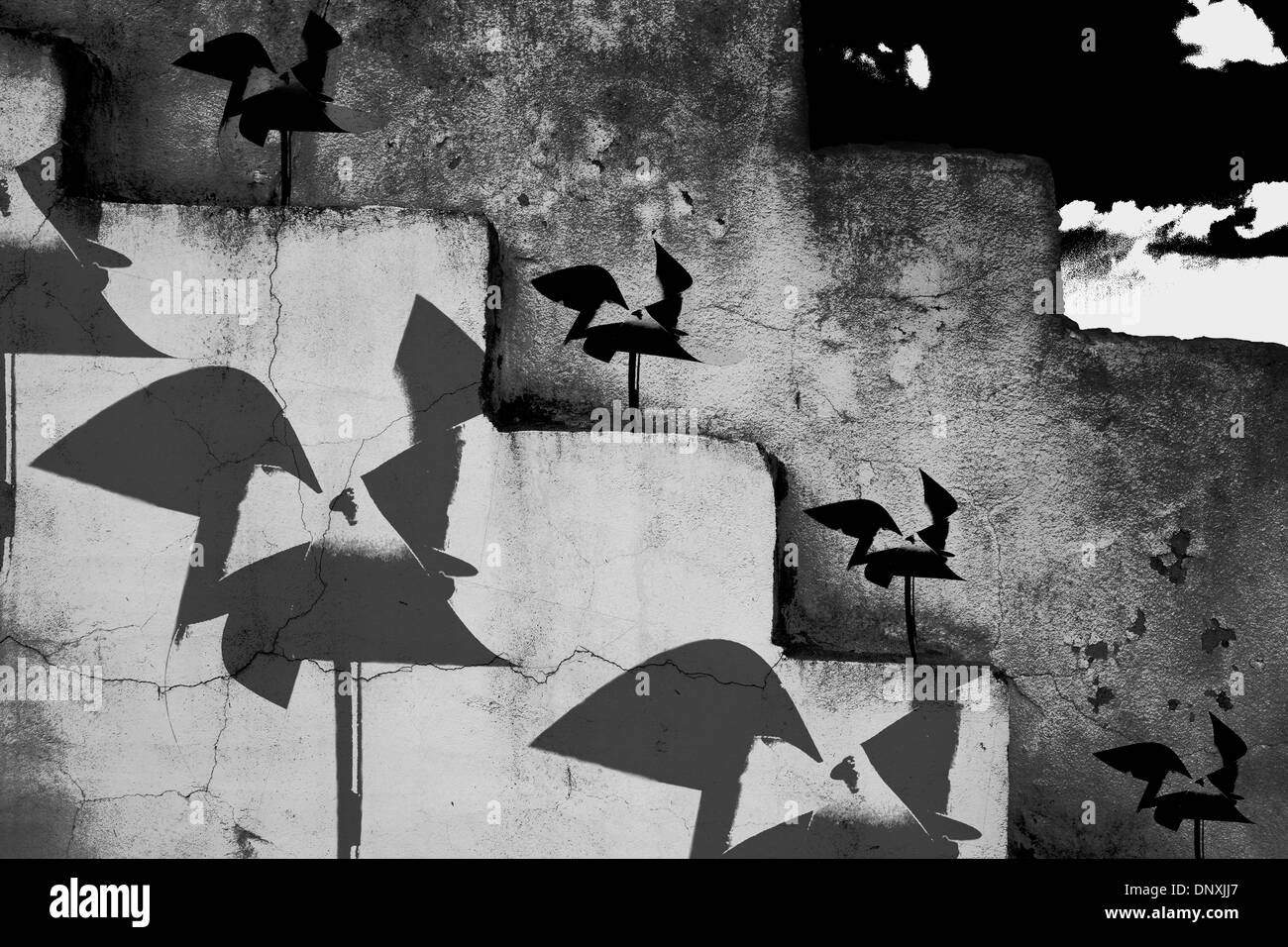 Pinwheels in un muro di pietra e di dare effetto desatura Foto Stock