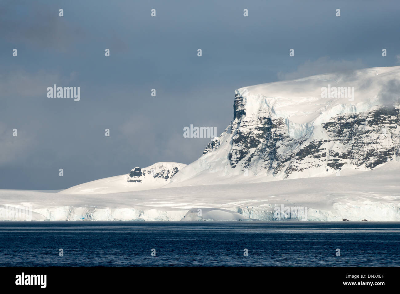 Antartide - una ripida scogliera ricoperto di ghiaccio e neve sorge sopra la costa di Gerlache stretto sul lato occidentale della penisola antartica. Foto Stock
