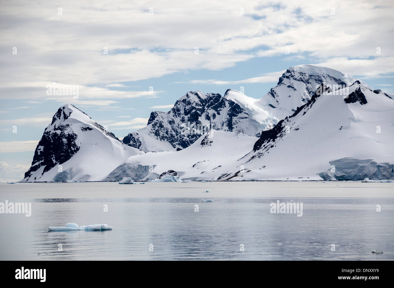 Antartide - aspre montagne rocciose salgono bruscamente sulla riva della penisola antartica vicino de Cuverville Island. Foto Stock