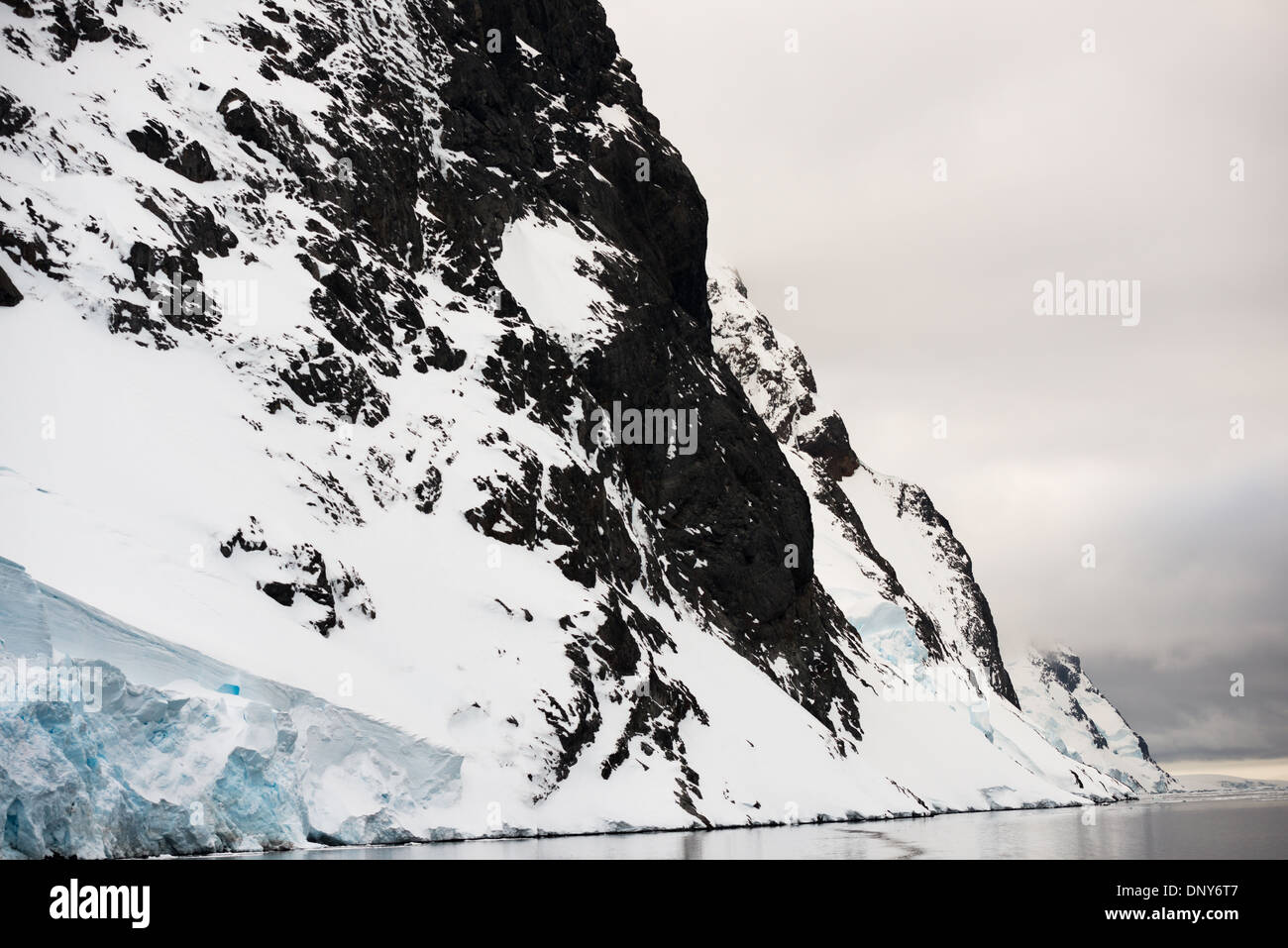 Antartide - ripide pareti rocciose arriva fino alla linea di galleggiamento del canale di Lemaire sulla costa occidentale della penisola antartica. Il Lemaire Channel è talvolta indicata come "Kodak Gap' in un cenno al suo famoso vedute panoramiche. Foto Stock