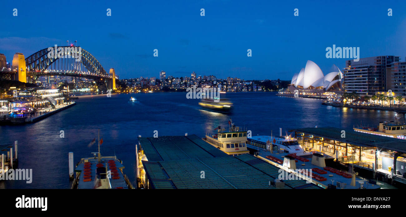 Il Circular Quay di notte con i traghetti arrivano, Harbour Bridge e Opera House Sydney New South Wales NSW Australia Foto Stock