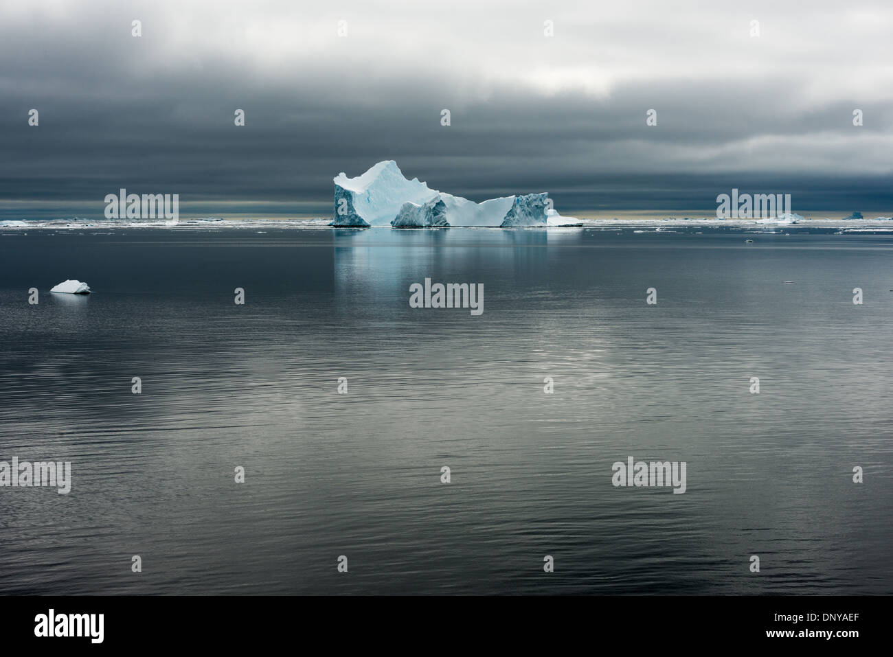 Antartide - Antartide Iceberg la sottile la colorazione si staglia contro le acque calme e cieli grigi vicino Galindez Island in Antartide. Foto Stock