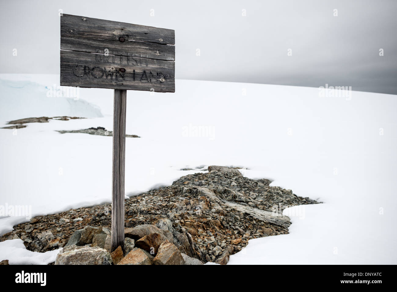 Antartide - un vecchio cartello in legno proclama la corona britannica terra vicino alla storica casa Wordie in Antartide. Originariamente conosciuto come Base F e più tardi rinominata dopo James Wordie, Chief Scientist su Ernest Shackleton principali della spedizione in Antartide, Wordie House risale al mid-1940s. Era uno di una manciata di basi costruito dagli Inglesi come parte di un segreto Guerra Mondiale II missione nome in codice Operazione Tabarin. La casa è conservato intatto e sorge nei pressi di Vernadsky Base di ricerca in Argentina isole in Antartide. Foto Stock