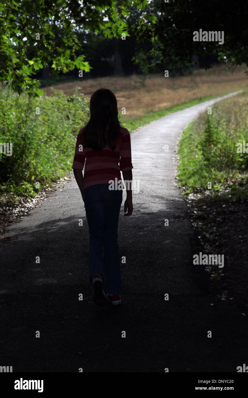Giovane ragazza camminare lungo un percorso. Torna alla telecamera. Foto Stock