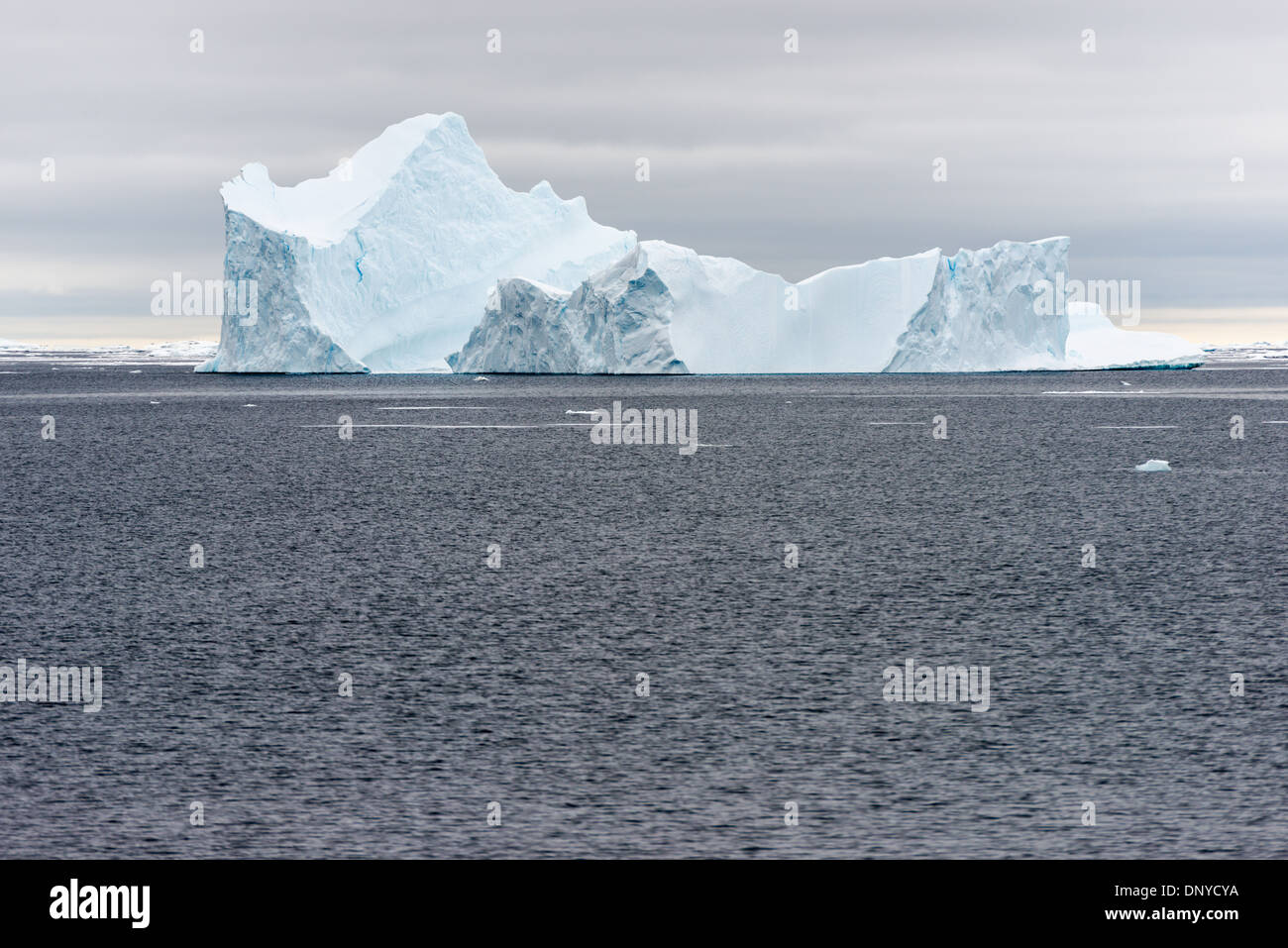 Antartide - un iceberg con ripidi fianchi jacked galleggia sulle acque grigie in Argentina le isole sul lato occidentale della penisola antartica. Foto Stock