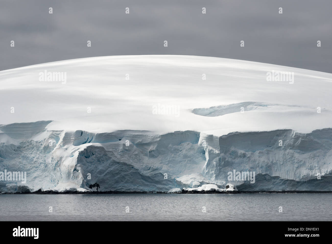 Antartide - La cupola delicatamente la parte superiore di un ghiacciaio contrasta con la frastagliata scogliera di ghiaccio dove incontra la linea di galleggiamento nei pressi di Melchior Island sulla penisola antartica. Foto Stock