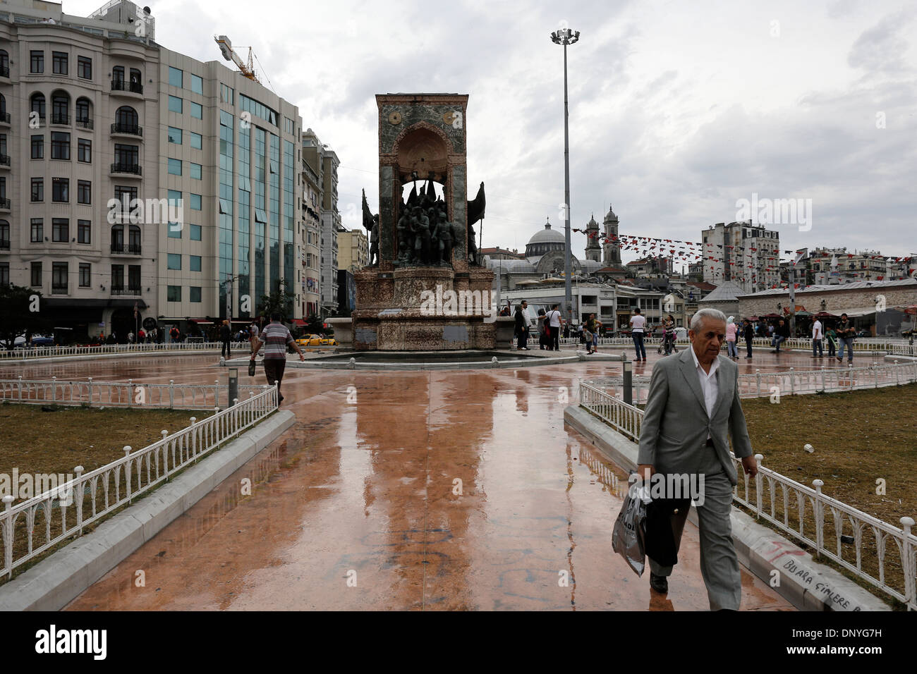 Un uomo cammina nella parte anteriore della Repubblica monumento situato in Piazza Taksim di Istanbul Foto Stock