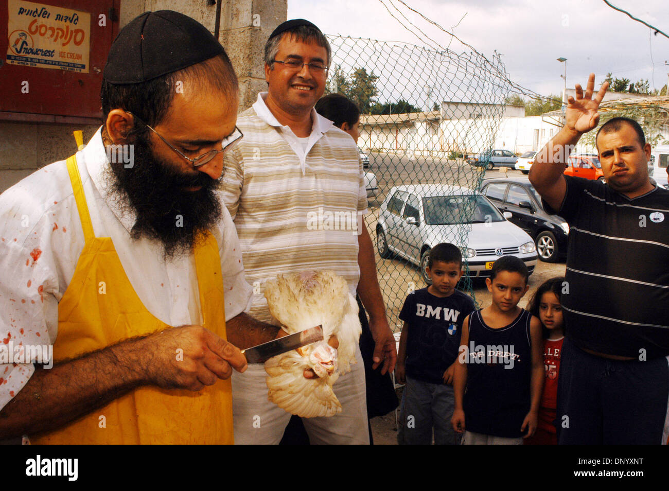 Oct 01, 2006 - Ashkelon, Israele - La cerimonia ebraica "Kaparot' viene eseguito da un ebreo Ultra-Orthodox uomo in un mercato a Ashkelon, Israele il 1 ottobre 2006. Questo rituale viene effettuata nei giorni prima di Yom Kippur il giorno dell'Espiazione - il santissimo giorno nell'anno Ebraico il 1 ottobre. Gli Ebrei religiosi swing un pollo bianco sopra le loro teste per trasferire i loro peccati al Foto Stock