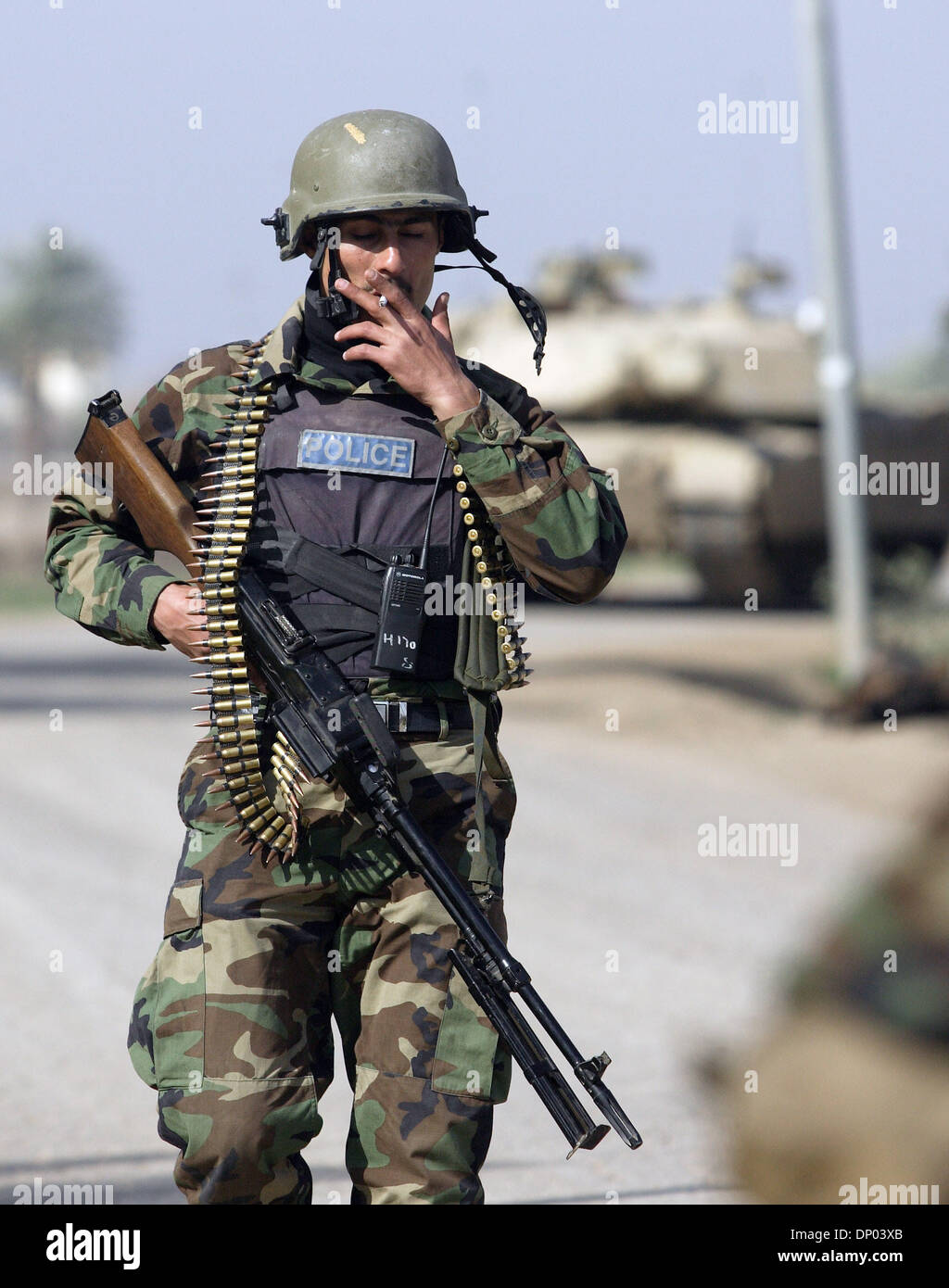 Feb 28, 2006; vicino a Ar Ramadi, Al Anbar, Iraq; un iracheno della polizia speciale Commando dal 2° Battaglione Brigata 2a, anche ampiamente noto come 'Wolf Brigata" prende una pausa sigaretta ed è sostenuta da un americano di M1A1 Abrams serbatoio, appena a nord della città irachena di Ar Ramadi su Feb 28, 2006. La polizia irachena sono stati su una missione congiunta con i soldati dal 101st airbourne in cerca di sospetti di io Foto Stock Feb 28, 2006; vicino a Ar Ramadi, Al Anbar, Iraq; un iracheno della polizia speciale Commando dal 2° Battaglione Brigata 2a, anche ampiamente noto come 'Wolf Brigata" prende una pausa sigaretta ed è sostenuta da un americano di M1A1 Abrams serbatoio, appena a nord della città irachena di Ar Ramadi su Feb 28, 2006. La polizia irachena sono stati su una missione congiunta con i soldati dal 101st airbourne in cerca di sospetti di io Foto Stock