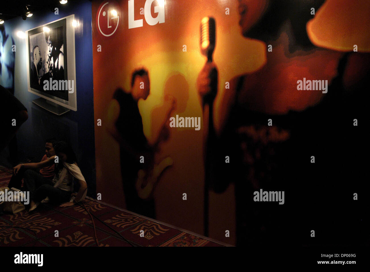 Mar 04, 2006; Jakarta, Indonesia; un giovane si siede di fronte a un segno pubblicità all'interno di un luogo durante il Jakarta International Java Jazz Festival 2006. Migliaia di appassionati di jazz hanno apprezzato la recitazione in tre giorni di festival di jazz. Raffigurata sul Mar 4, 2006. Credito: Foto da Ng Swan Ti/JiwaFoto/ZUMA premere. (?) Copyright 2006 by JiwaFoto Foto Stock