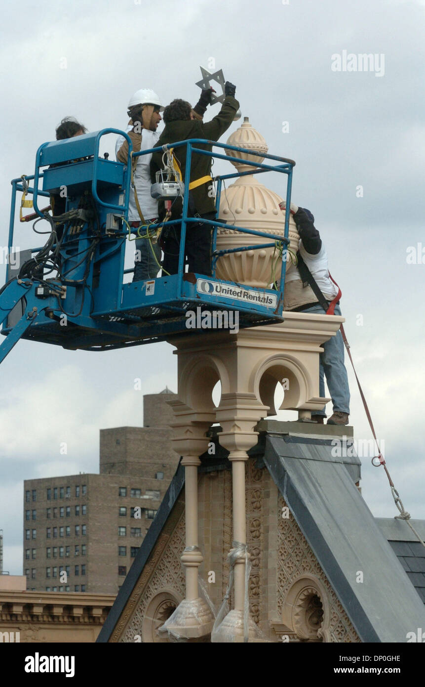 Mar 19, 2006; Manhattan, New York, Stati Uniti d'America; Eldridge Street fondatore del progetto ROBERTA GRATZ luoghi la stella di Davide in cima alla torre. Il sollevamento e ancoraggio della centrale Terminale per tenda ornamentali completa il restauro della facciata del Eldridge Street sinagoga. La Eldridge Street sinagoga è la prima sinagoga di New York costruito da Oriente Ebrei europei ed è stato completato nel 1887 ed è cittadino Foto Stock