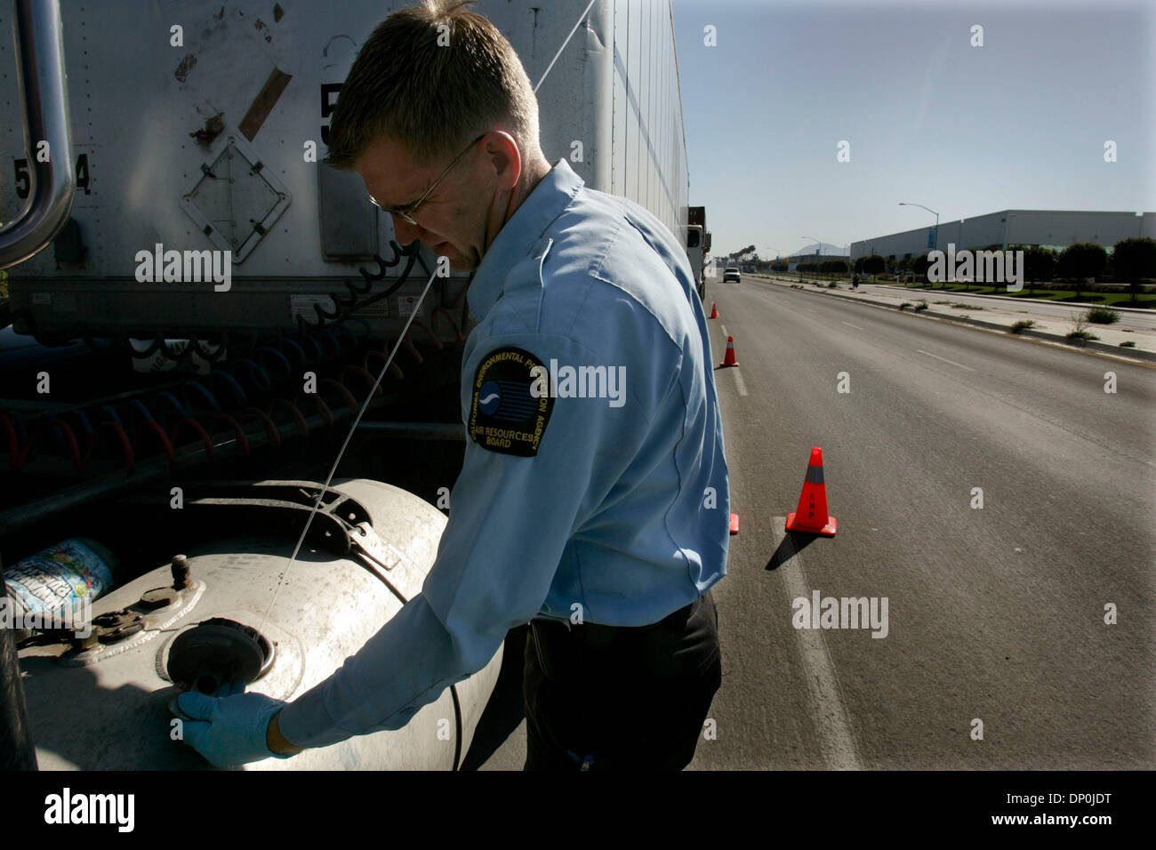 Mar 22, 2006; Otay Mesa, CA, Stati Uniti d'America; JOHN TURNBULL, un California Air Resources Board rappresentante del campo II controlla il serbatoio del gasolio di un carrello in un California Air Resources Board e CHP stazione di ispezione sul Sempre viva per unità. TURNBULL controllato il carburante per vedere se era un colorante Rosso, Diesel diesel che ha il colorante rosso aggiunto e non è inteso per uso non stradale e costa circa 50 centesimi Foto Stock