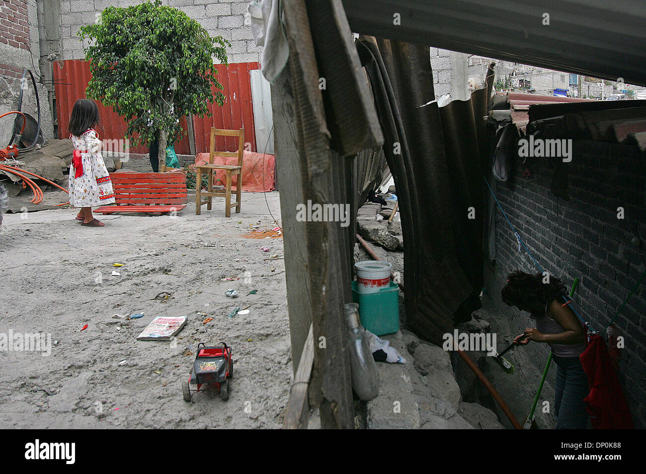 Mar 24, 2006; Ecatepec, Messico; Sandra Ruiz, 35, pulisce attorno alla sua casa come neghborhood giocare i bambini nel patio Ecatepec, Messico. Con suo marito lavora in California, sperano di ampliare la loro camera una casa di tre stanze per meglio accogliere i 11 membri della famiglia. Credito: Foto di Jerry Lara/San Antonio Express-News/ZUMA premere. (©) Copyright 2006 da SA Foto Stock