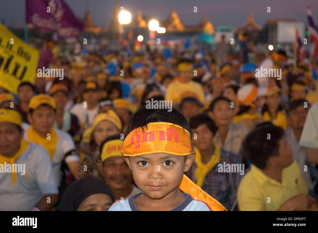 Apr 07, 2006; Bangkok, Thailandia; un ragazzo si erge di fronte seduto manifestanti con la Grand palce in distanza. Dopo mesi di campagne, manifestanti portano dai popoli Alleanza per la democrazia (PAD) sciame a Sanam Luang Royal Park a Bangkok, in Thailandia il 7 aprile 2006. Essi sono qui per celebrare la loro vittoria. Thaksin Shinawatra, il primo ministro ha deciso di fare Foto Stock