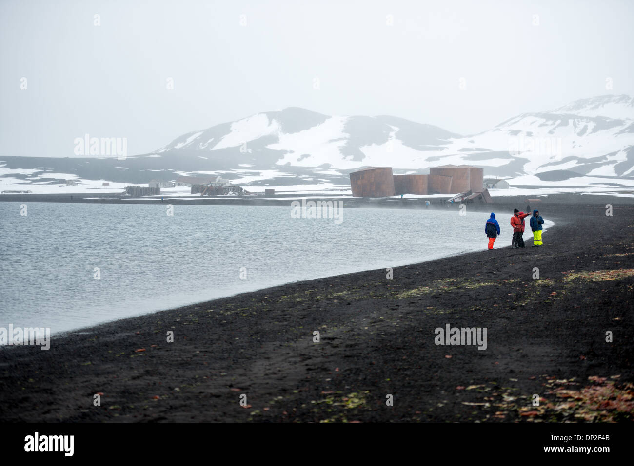Antartide - La spiaggia di Whalers Bay, isola Deception, con le rovine della abbandonata la stazione baleniera in background. Isola Deception, a sud le isole Shetland, è una caldera di un vulcano ed è composta di roccia vulcanica. Foto Stock