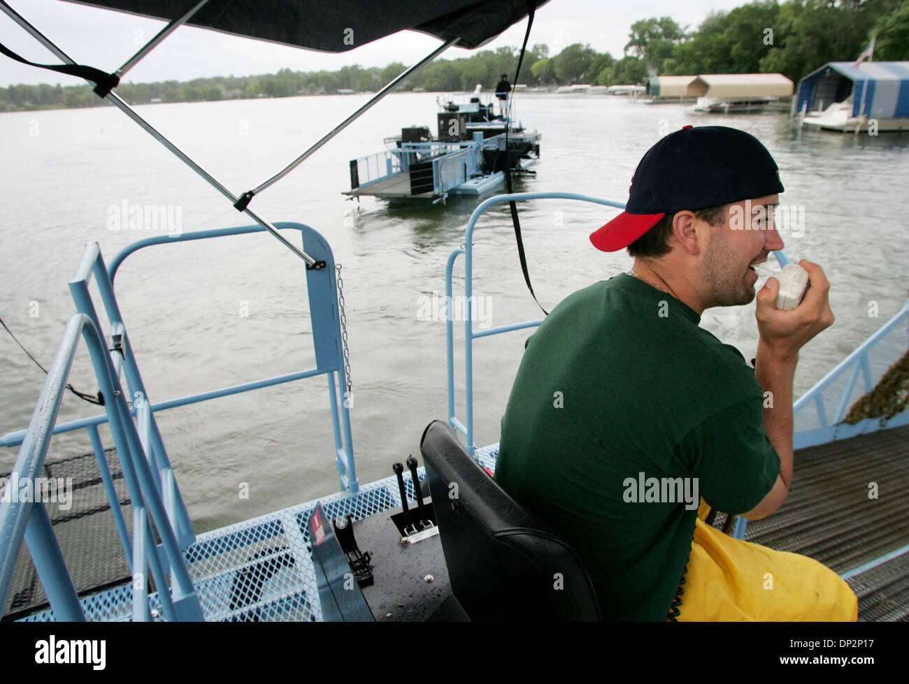 Jun 09, 2006; Spring Park, MN, Stati Uniti d'America; Jon Septer, destro con il lago Minnetonka Conservation District, comunica via radio con un pontone conducente cercando achillea nel vecchio Chanel area del Lago Minnetonka. Il LMCD tre achillea mietitrici e uno transporter erano fuori sul lago per la prima volta questa estate il Venerdì. Credito: Foto di Jennifer Simonson/Minneapoli Foto Stock