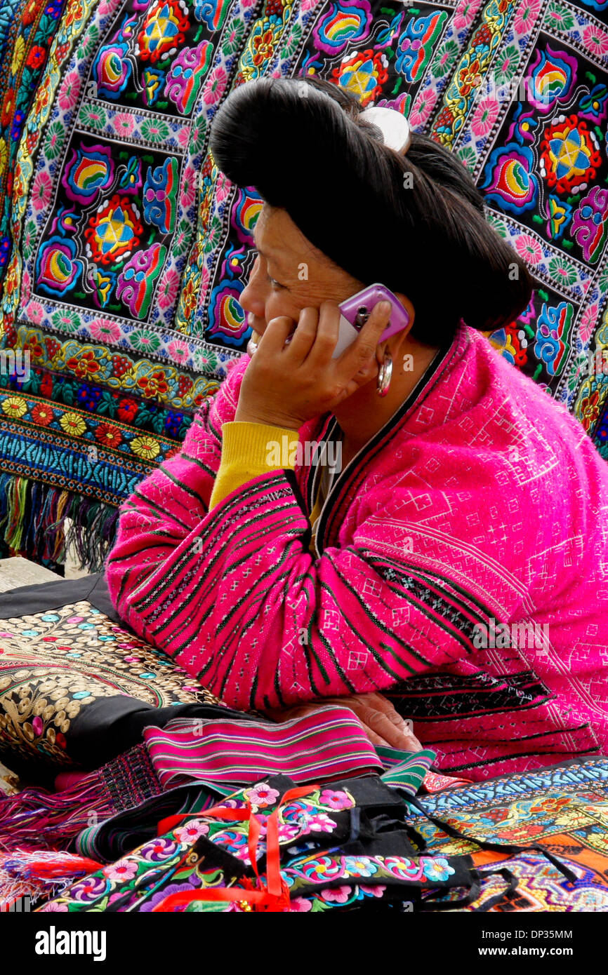 Donna di Red Yao minoranza etnica parlando al cellulare in stallo artigianale, Longsheng (Longji), Guangxi, Cina Foto Stock