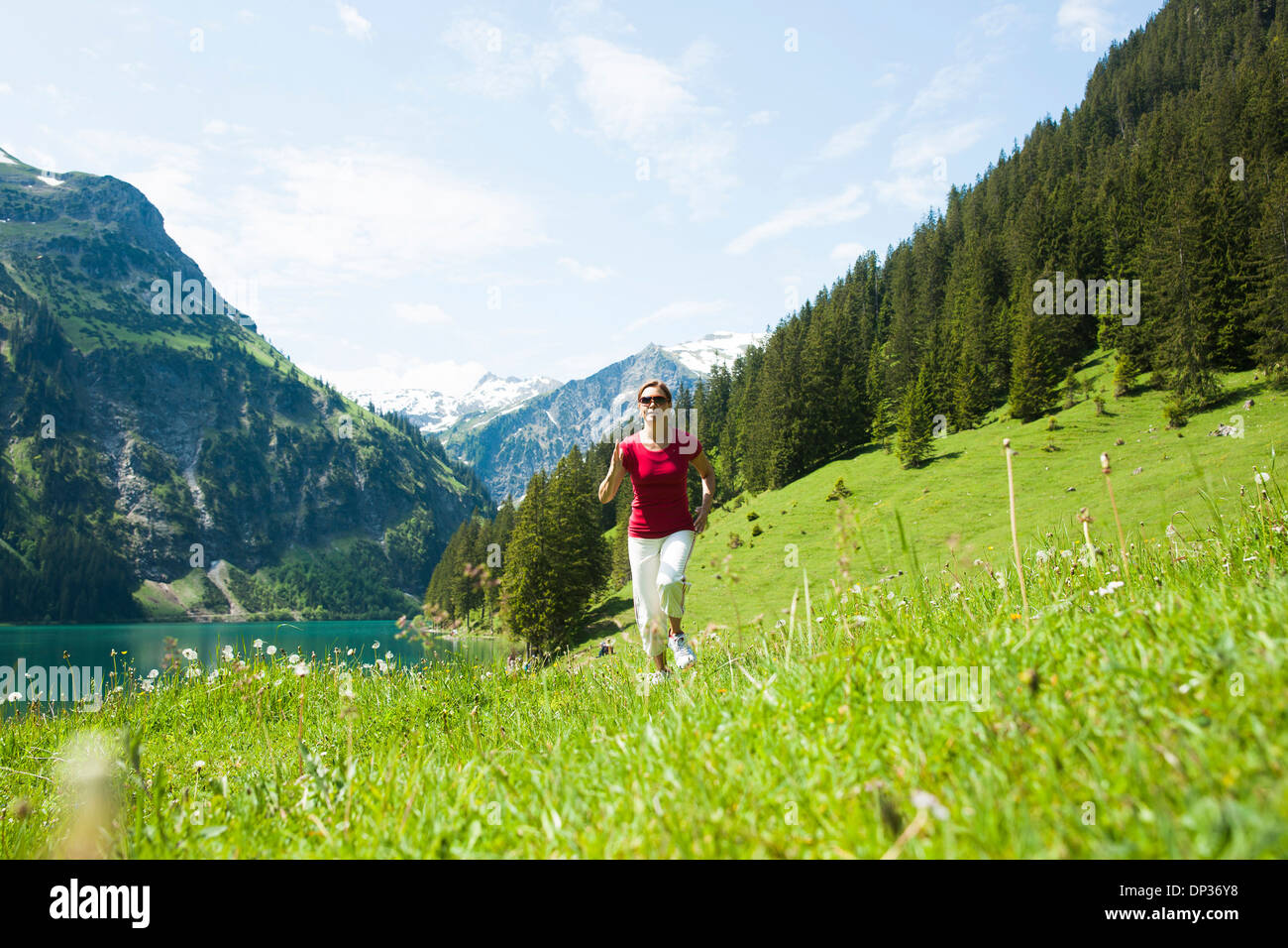 Donna matura power walking, Lago Vilsalpsee, Valle di Tannheim, Austria Foto Stock