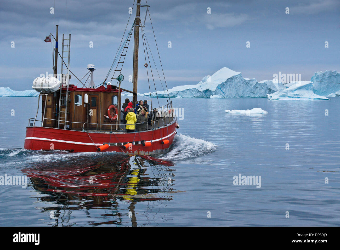 I turisti in barca da pesca tra gli iceberg nella baia di Disko, Ilulissat, Groenlandia occidentale Foto Stock