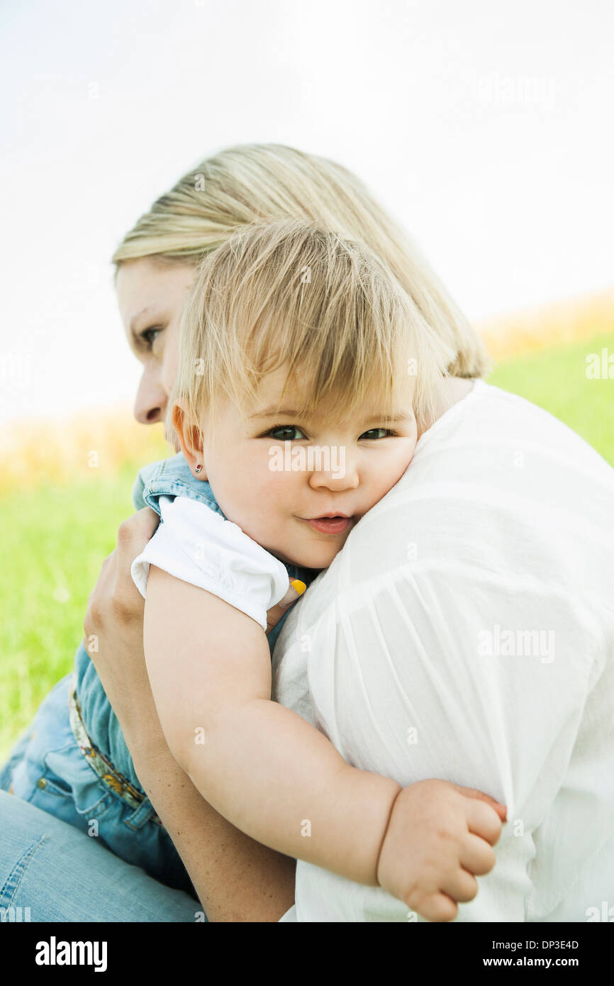 Madre abbracciando la nostra bambina all'aperto, Mannheim, Baden-Württemberg, Germania Foto Stock