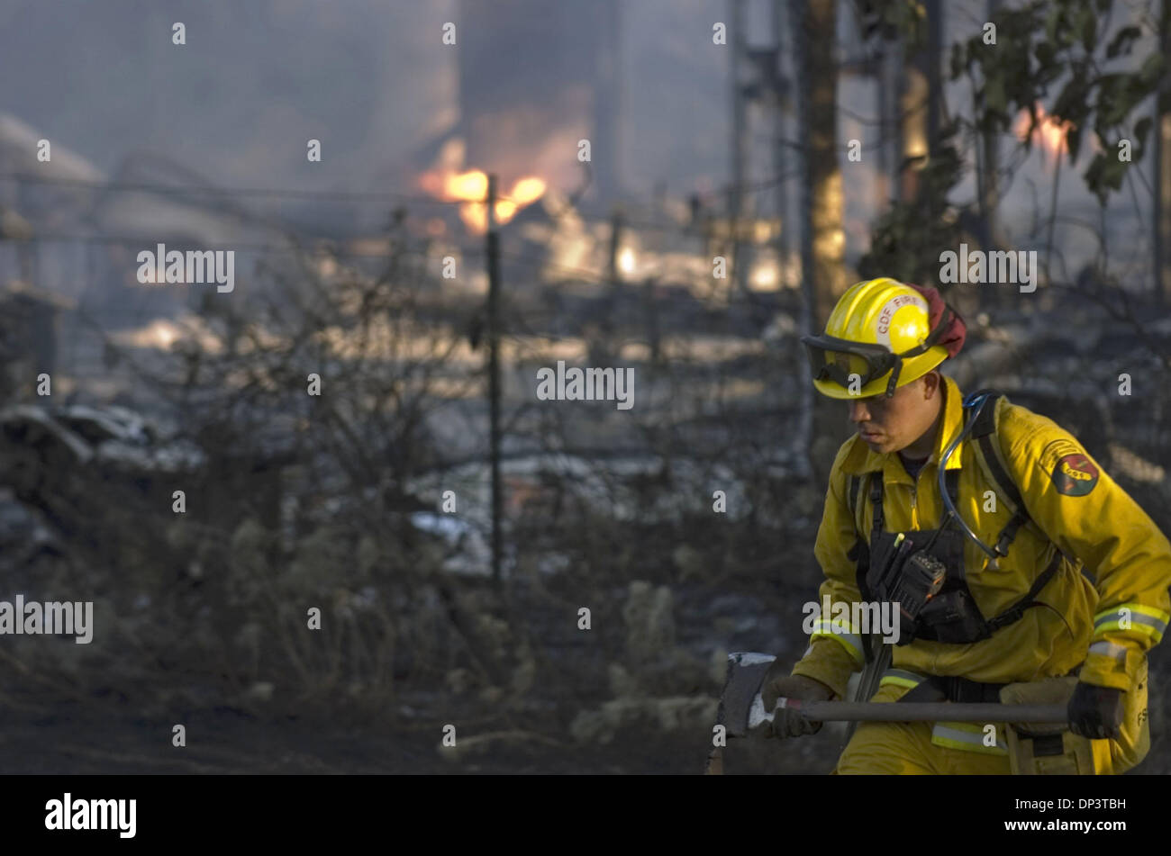 Jul 16, 2006; El Dorado, CA, Stati Uniti d'America; un misterioso CDF pompiere cerca i punti caldi come i resti di una casa sul Monitor Road, continuare a bruciare durante la Domenica di molteplici incendi lungo l'autostrada 49 e monitorare la strada in El Dorado County Luglio 16, 2006. Credito: Foto di Manny Crisostomo/Sacramento Bee/ZUMA premere. (©) Copyright 2006 by Sacramento Bee Foto Stock