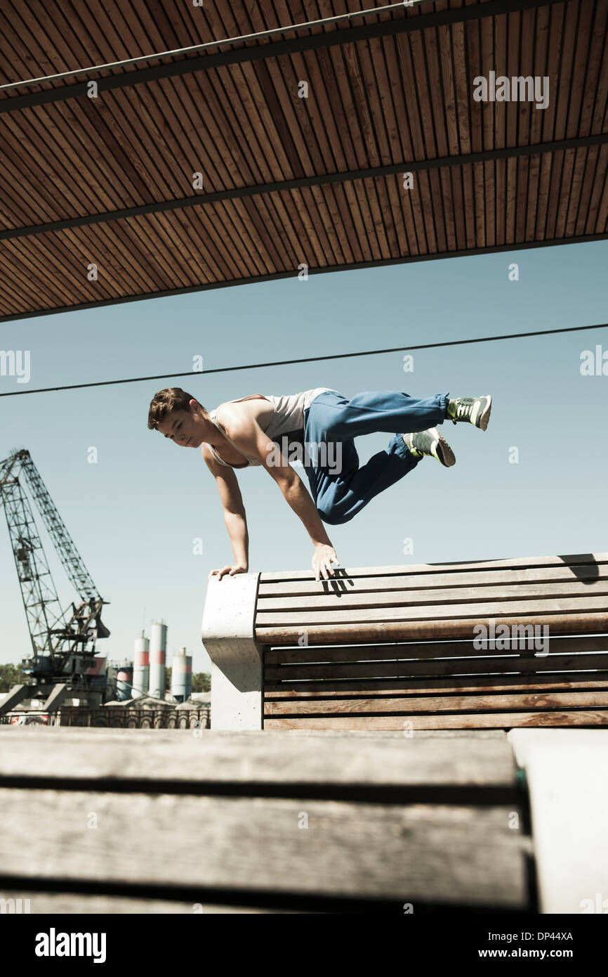 Ragazzo adolescente saltando su barriera, freerunning, Germania Foto Stock