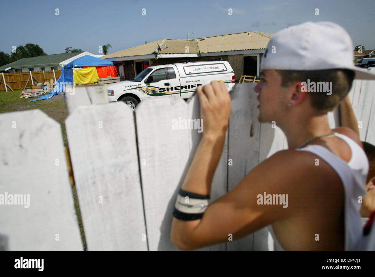 Jul 29, 2006; Porta St. Lucie, FL, Stati Uniti d'America; Chris Rader, 17 picchi di oltre un alto recinto per ottenere una vista migliore come la polizia indaga il luogo di sepoltura di Julia M. Rolan-Estrada. Credito: Foto di Amanda Voisard/Palm Beach post/ZUMA premere. (©) Copyright 2006 da Palm Beach post Foto Stock