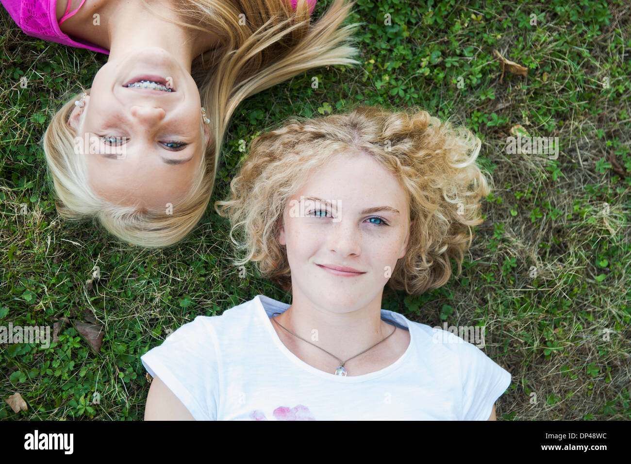 Vista aerea di ragazze adolescenti giacente su erba, Mannheim, Baden-Württemberg, Germania Foto Stock
