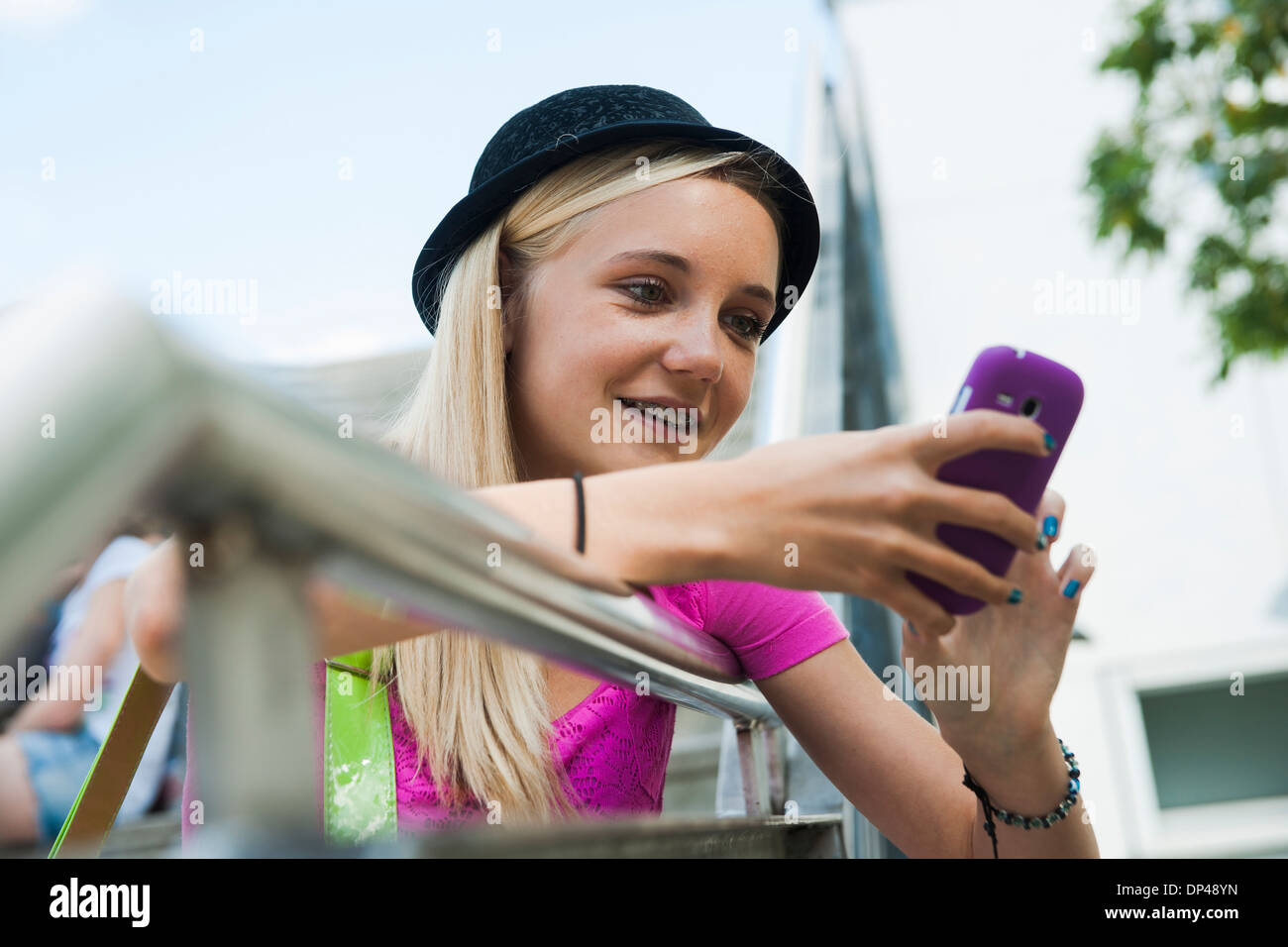 Ragazza adolescente tramite telefono cellulare all'aperto, Mannheim, Baden-Württemberg, Germania Foto Stock