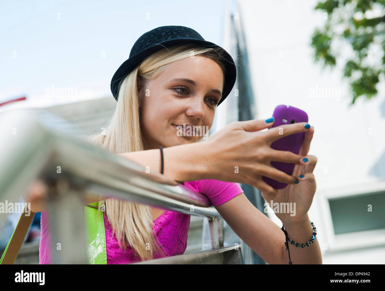 Ragazza adolescente tramite telefono cellulare all'aperto, Mannheim, Baden-Württemberg, Germania Foto Stock