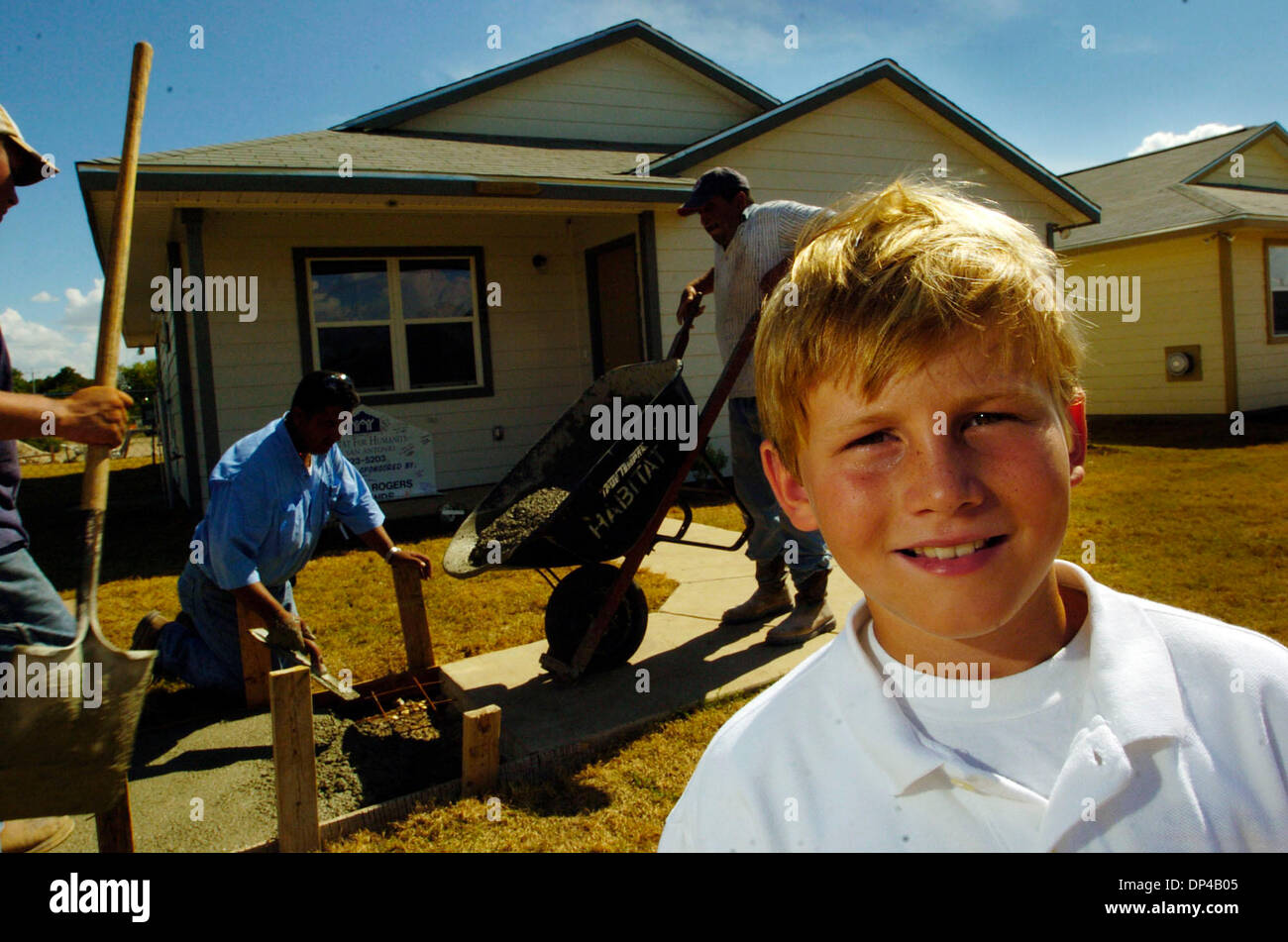 Aug 04, 2006; San Antonio, TX, Stati Uniti d'America; Jackson Rogers, 10, si trova davanti la casa che lui stesso ha contribuito a costruire sul lato sud di San Antonio, e il Agosto 4, 2006. La colata di cemento sono Issac Espinoza, Louis Aguilar e Edward Aguilar di ACS Aguilar servizi concreti. Rogers ha sollevato $43.000 per l'Habitat per l'umanità perché voleva costruire una casa per i senzatetto. Ha ottenuto di $100 e una sfida da hi Foto Stock