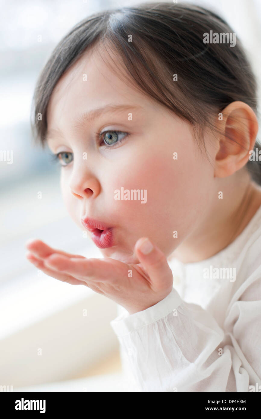 Bimba di tre anni soffia un bacio Foto Stock