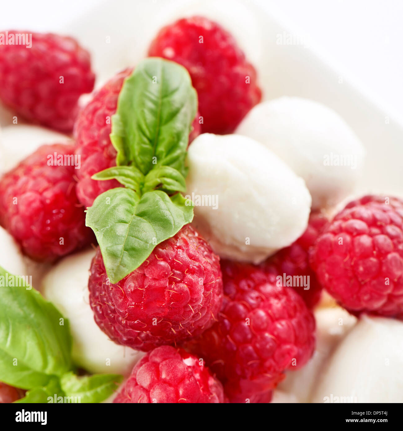 Sani e freschi di lampone e mozzarella insalata servita in un recipiente quadrato Foto Stock