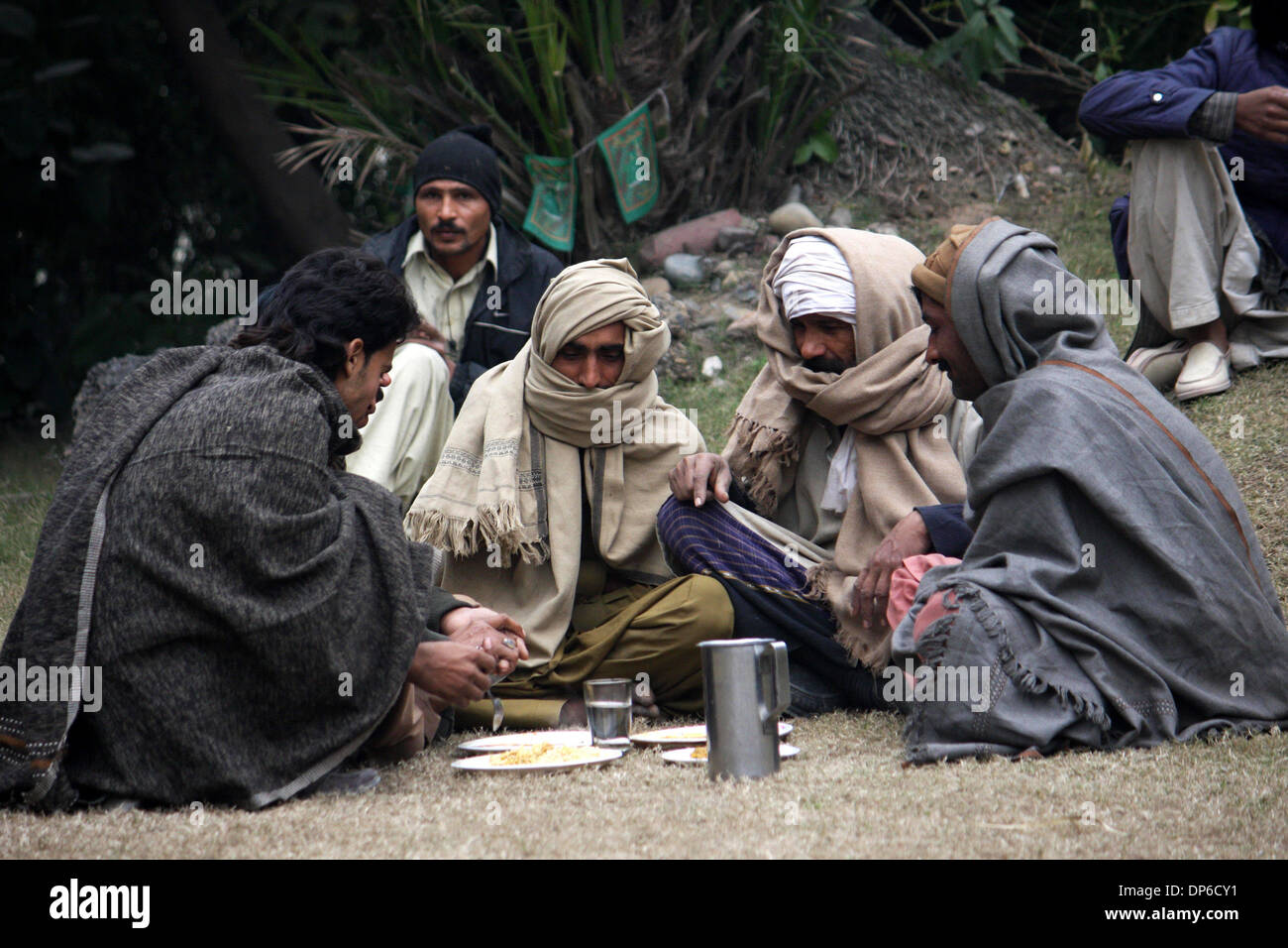 Lahore. 8 Gen, 2014. Operai pakistani chat come scudo essi stessi da un ondata di freddo in Pakistan orientale di Lahore, 8 gennaio, 2014. © Jamil Ahmed/Xinhua/Alamy Live News Foto Stock