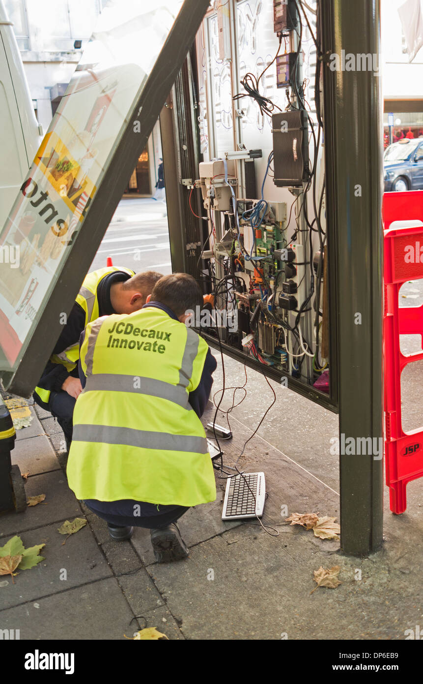 Ingegneri fissare il funzionamento interno di un bus stop sito poster Foto Stock