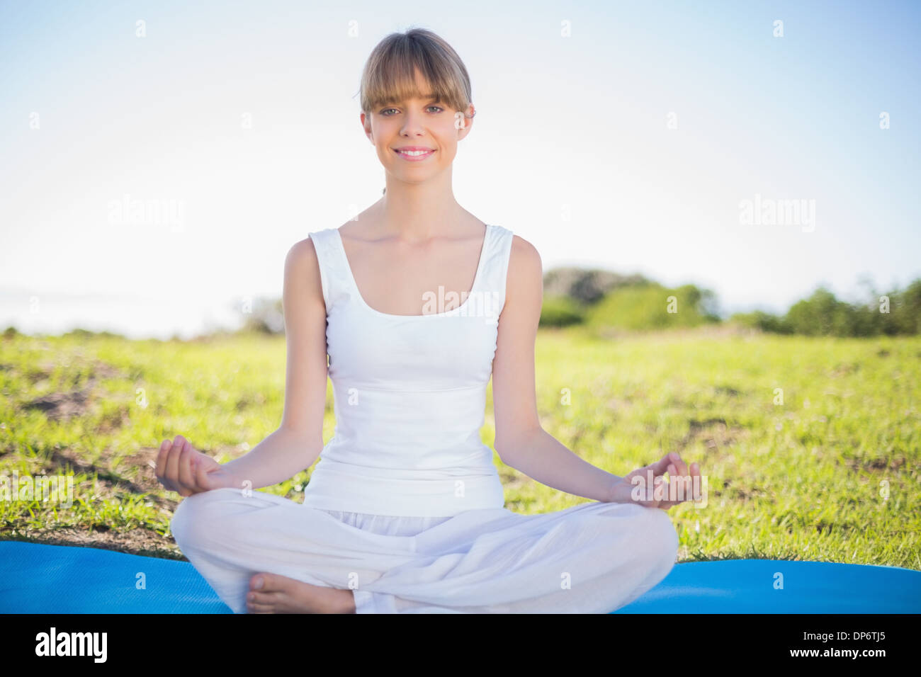 Naturale sorridente giovane donna fare yoga Foto Stock
