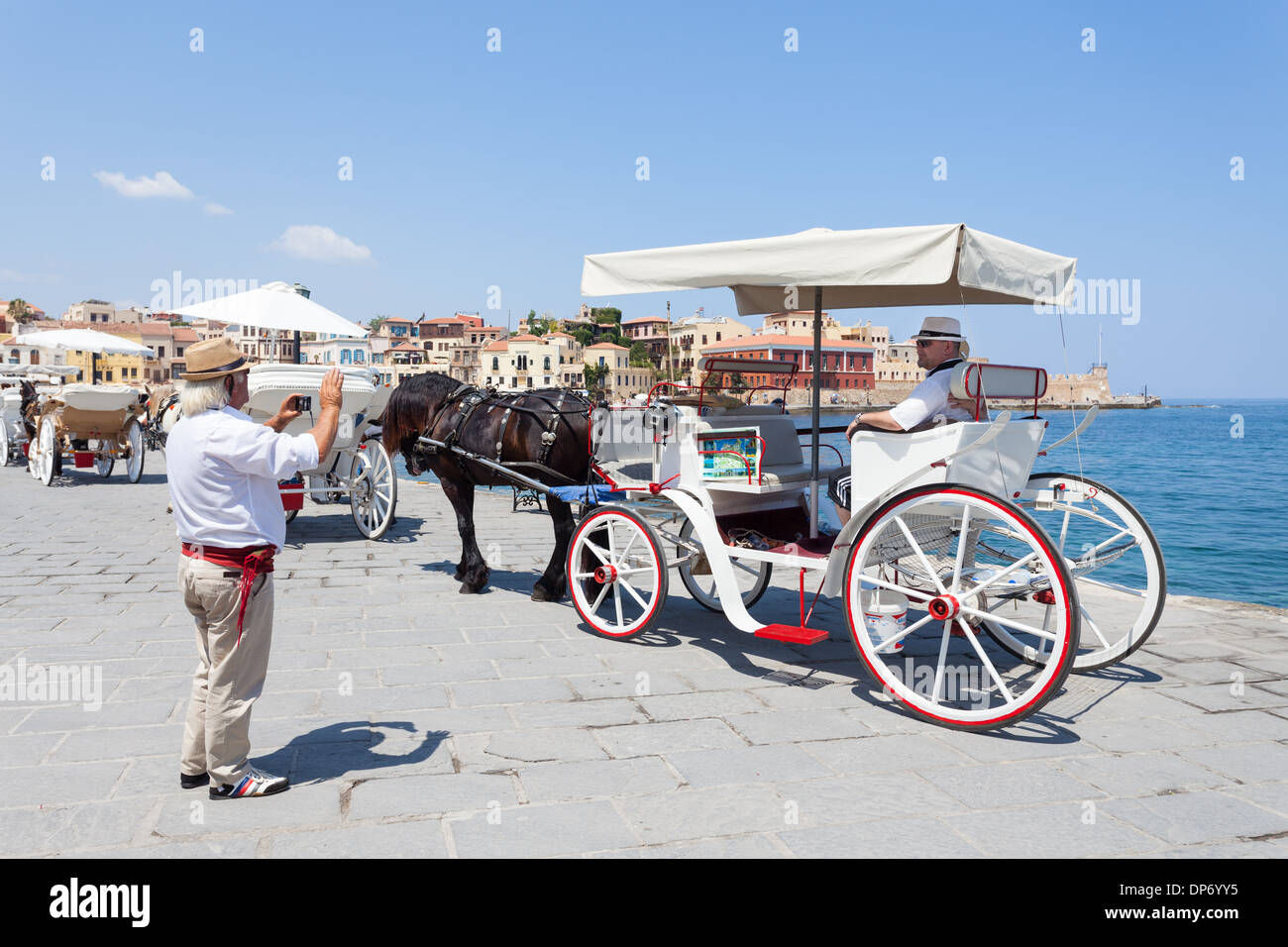Driver di carrello di scattare una foto dei suoi clienti nel porto di Chania, Creta, Grecia Foto Stock