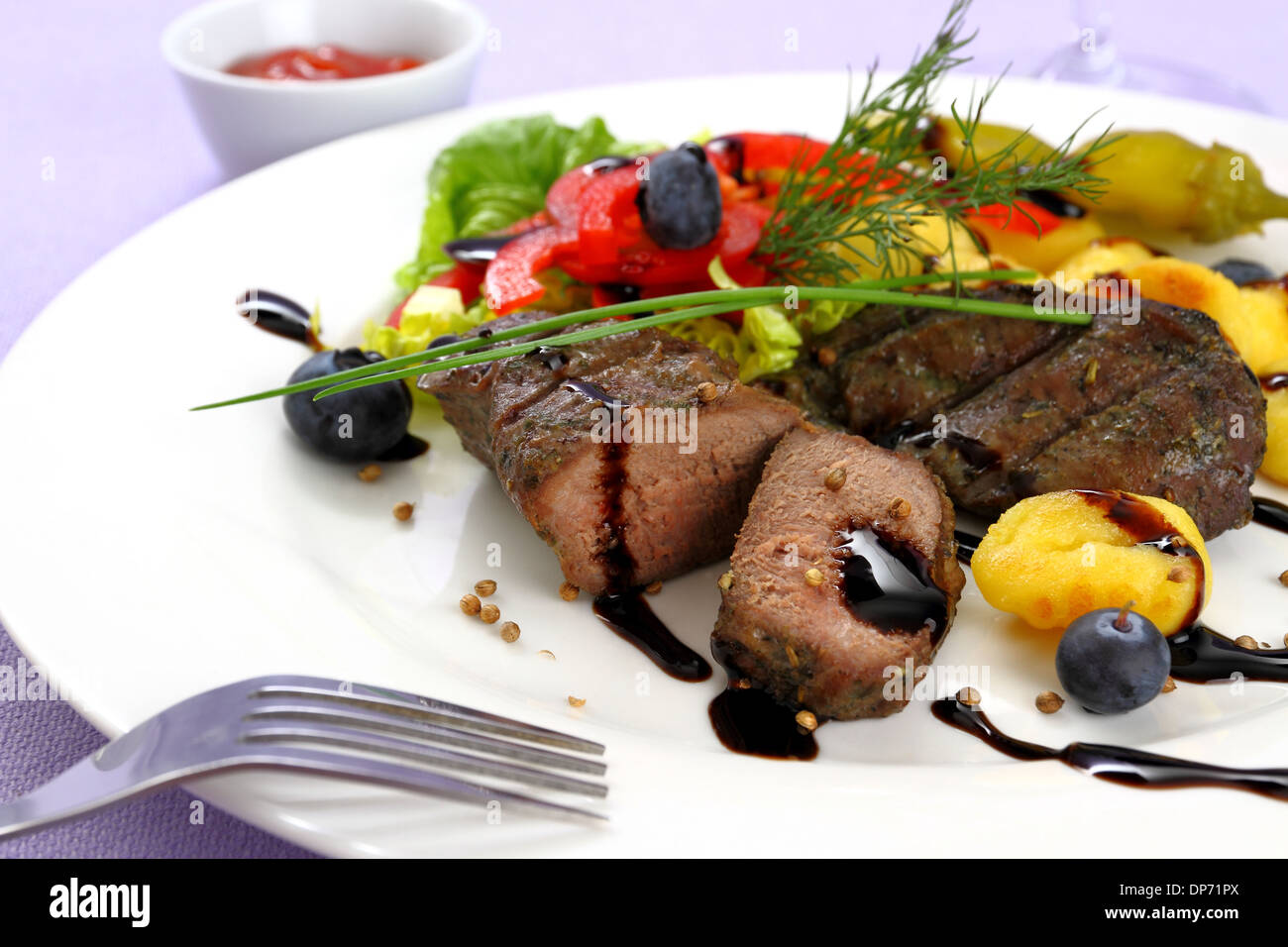 Bistecca di agnello con patate, verdure e salsa balsamica, close up Foto Stock
