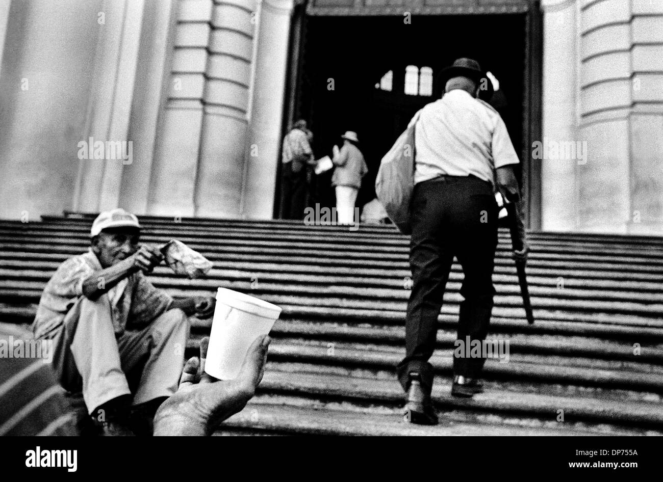 Jan 01, 2001; n/a, EL SALVADOR; passando dal - al di fuori della Cattedrale San Salvador, ben vestito parrocchiani passano da mendicanti disabili sui gradini sul loro modo di sera messa. I poveri in El Salvador e in altri paesi simili in tutto il mondo deve poter contare su assistenza estera, spesso da parte degli Stati Uniti, perché essi trovano la loro migliore-off connazionali disposti ad aiutare, o anche riconoscere tha Foto Stock