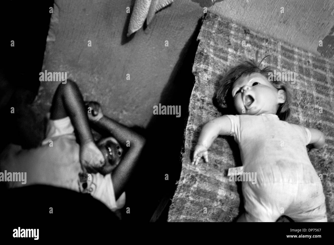 Jul 20, 2005; Città del Guatemala, Guatemala; grido silenzioso - Un bambino piange silenziosamente sotto la sua bambola ad una casa per bambini disabili vicino a Città del Guatemala Il Guatemala. Le grida dei disabili sono raramente sentito nei paesi in via di sviluppo, dove essi sono spesso evitato, ignorati o emarginati in sottofinanziata strutture. Credito: Foto di Benjamin Rusnak/ZUMA premere. (©) Copyright 2005 by B Foto Stock