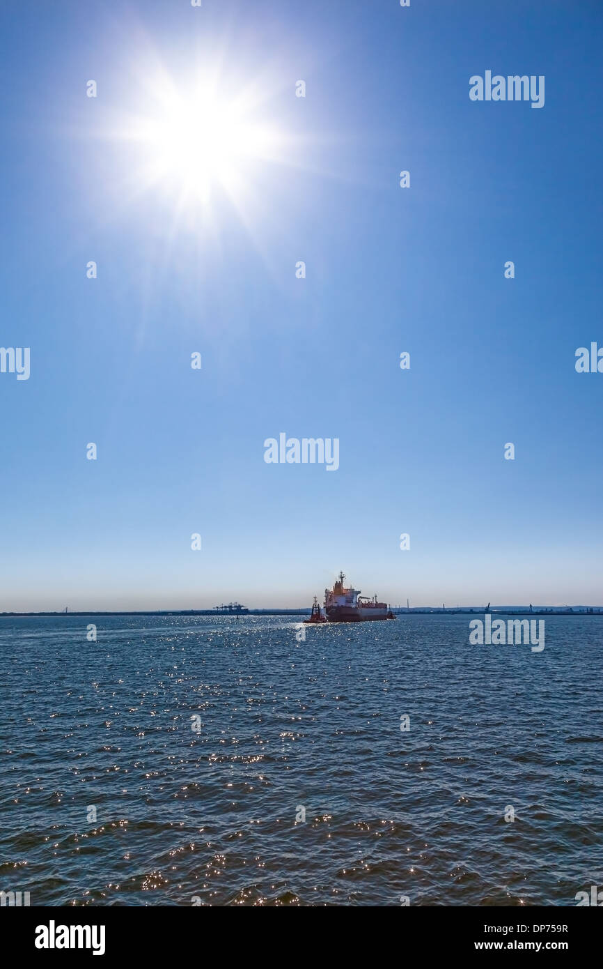 La nave galleggiante sul mare con il sole che splende in cielo blu. Foto Stock