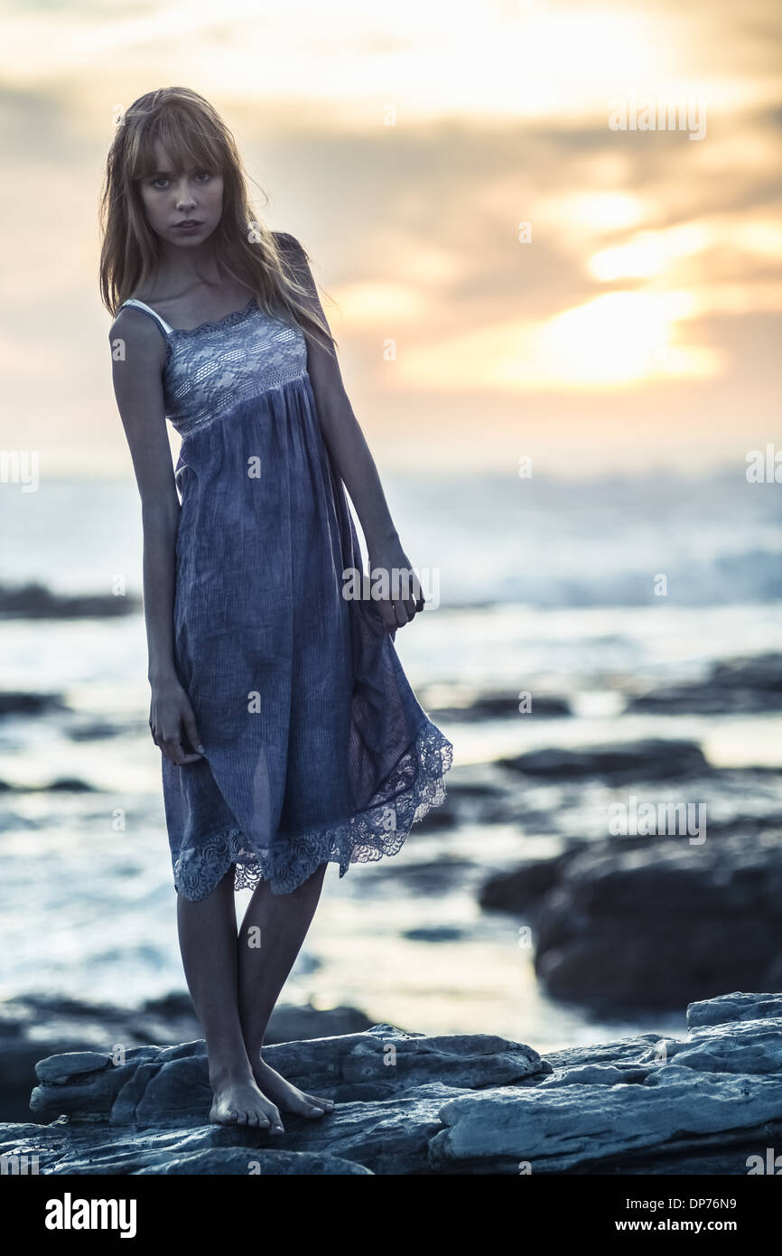 Bellissimo modello in piedi sulle rocce in riva al mare Foto Stock