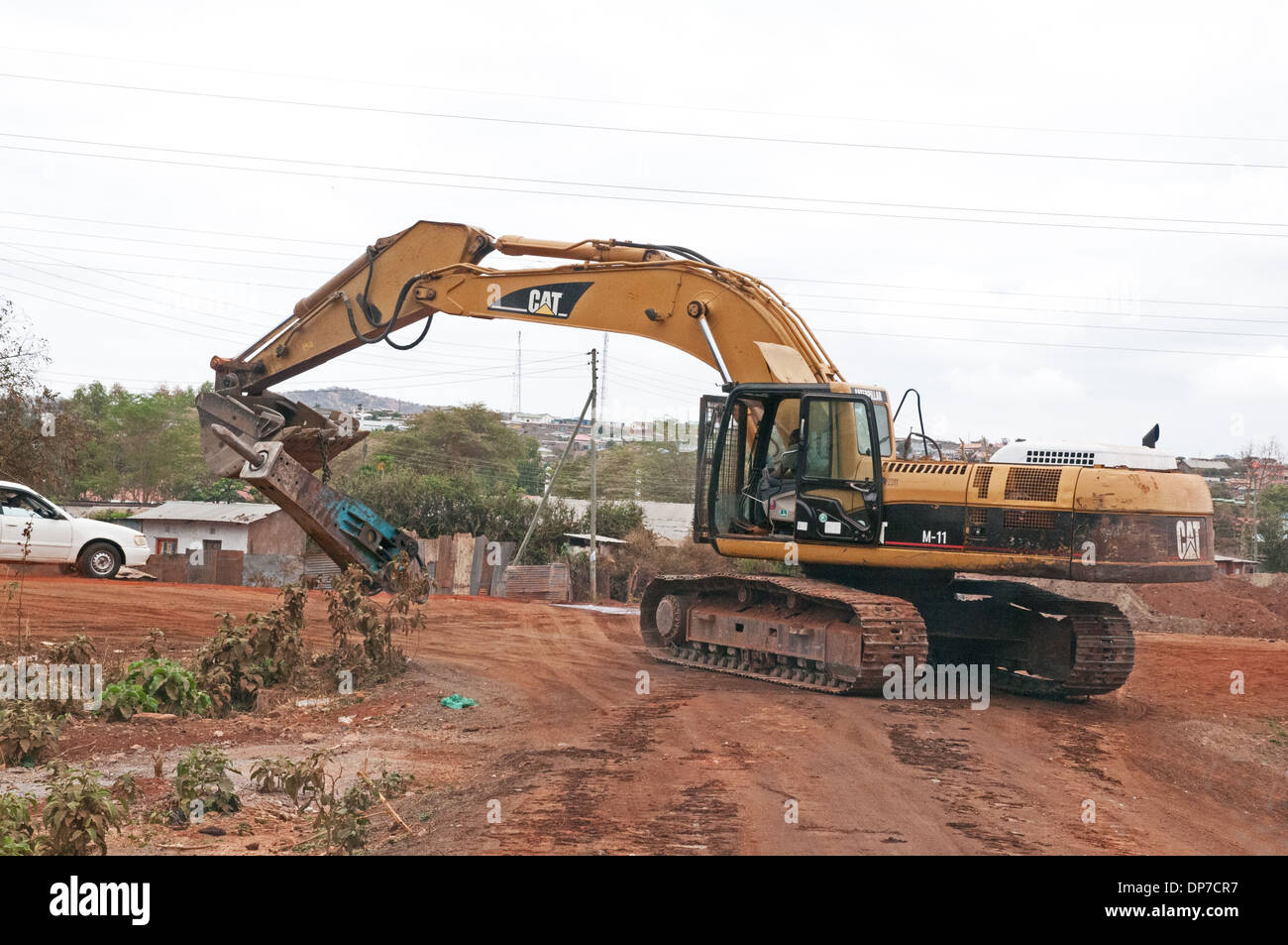 CAT Caterpillar escavatore idraulico sollevamento lavorando su strada dei miglioramenti a Namanga Kenya Africa Foto Stock