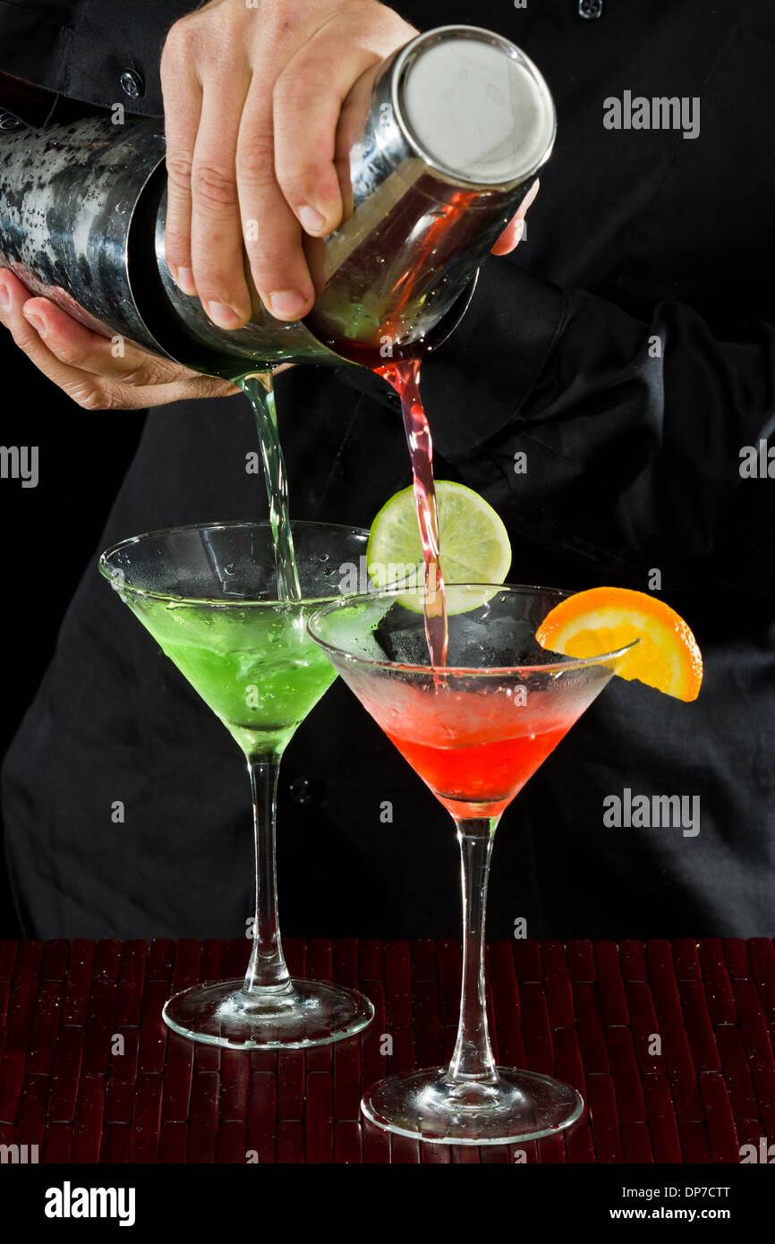 Professional Bartender versando due Martini al tempo stesso in un movimento fluido Foto Stock